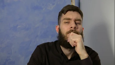 Emotion. A man with a beard looks at the camera and shakes his head. Stock Footage 123824963