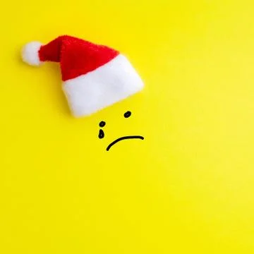 Emotion of a sad crying face painted on a yellow background under the red San Stock Photos