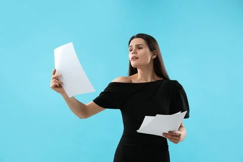 Emotional actress with script performing on light blue background. Film ind.. Stock Photos