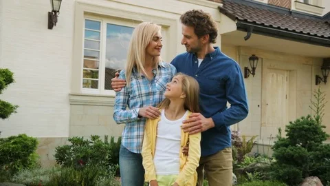 Emotional beatiful couple hugging their daughter and smiling on camera in front Stock Footage