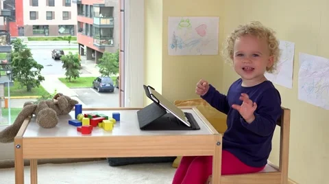 Emotional child using tablet computer. Poor teddy bear laying on table Stock Footage 68017548