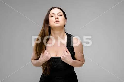Emotional confident plus size model standing in studio showing her sexuality on Stock Photos