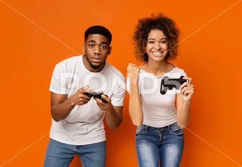 Emotional girl winning to her boyfriend, enjoying success with joystick Stock-Fotos