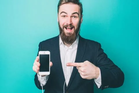Emotional guy is standing and pointing on the phone. Also he is looking to the Foto stock