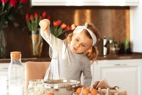 Emotional happy child cooking cake for Father day party in white sunny kitche Stock Photos