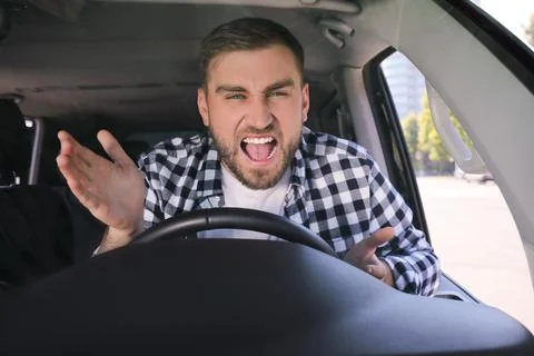 Emotional man in car. Aggressive driving behavior Stock Photos