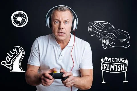 Emotional man feeling interested while playing video games Fotos de archivo