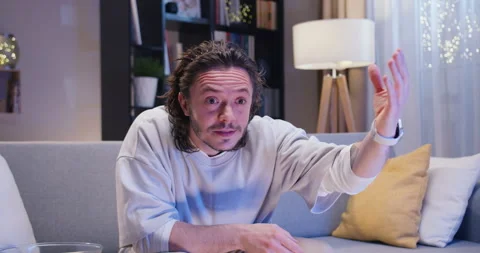 Emotional man sitting on comfortable couch and watching sport match with Stock Footage 244144091