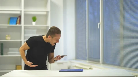 The emotional man throwing the phone on the table. slow motion Vídeos de archivo 99227578