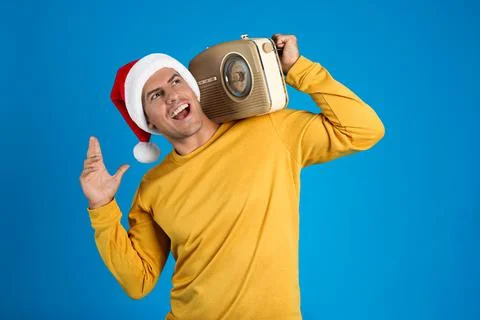 Emotional man with vintage radio on blue background. Christmas music Stock Photos
