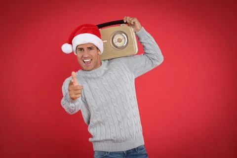 Emotional man with vintage radio on red background. Christmas music Stock Photos
