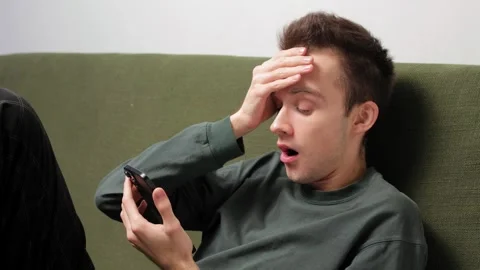 Emotional reaction of a young man using smartphone Video stock 301520428