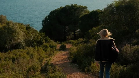 Emotional Slow motion back view of Lone Tourist Woman going on forest Path Video stock 246010863