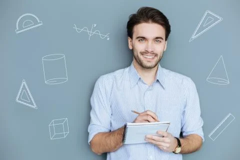 Emotional student holding a notebook while having his Math lesson Stock Photos
