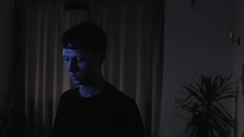 Emotionally drained man standing alone with a downcast gaze, experiencing 스톡 동영상 347299783