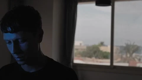Emotionally drained man walking into frame and standing with a downcast gaze Stock-Footage 347300867