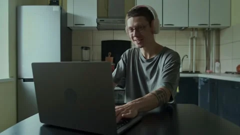 Emotions while playing on a laptop. Focused gamer wearing headphones intensely Stock Footage 310374741