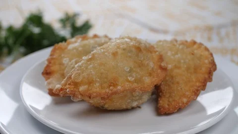 An empanada is a type of baked or fried pasty, consisting of pastry and filling, Stock Footage 95817009