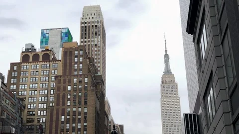 Empire State Building tilting to crowded street 8th Avenue people Manhattan NYC 動画素材 107342427