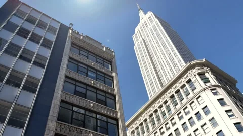 Empire State Building upward angle sun beaming sunny day blue sky Manhattan NYC 스톡 동영상 164937294