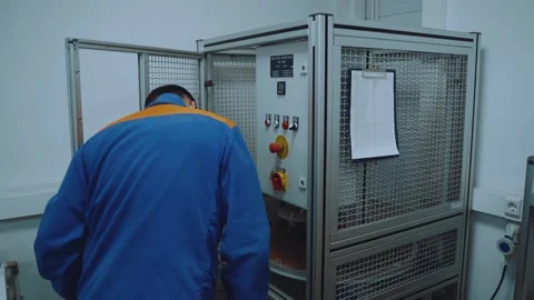 An employee approaches the machine, checks it and turns it on 스톡 동영상 165949473