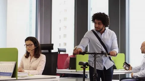 Employee with bicycle saying goodbye when leaving office at 5 pm Stock Footage 67346963