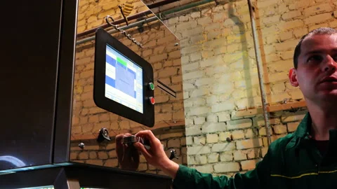 The employee carefully performs the settings of the equipment on the touch Stock Footage 92619993