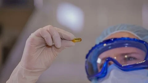 An employee is checking the appearance of a yellow pill Stock Footage 71528769
