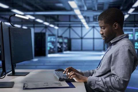 Employee checking for signs of tech failure in data center supercomputers Stock Photos