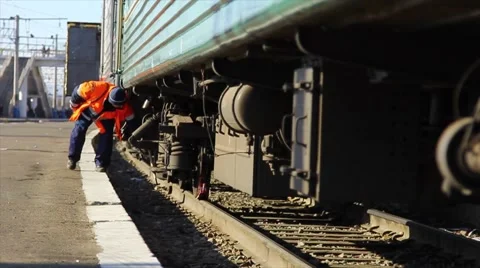 An employee checks the condition of the train. Stock Footage 64636180