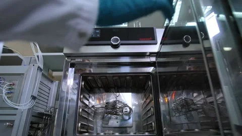 Employee closes door of machine tool doing tests in lab Stock Footage 148660851