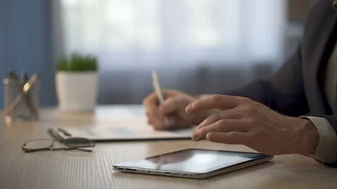 Employee comparing data on tablet and paper graphs, presentation of final data Stock Footage 76156977