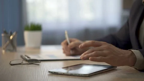 Employee comparing data on tablet and paper graphs, presentation of final data Stock Footage 76165238