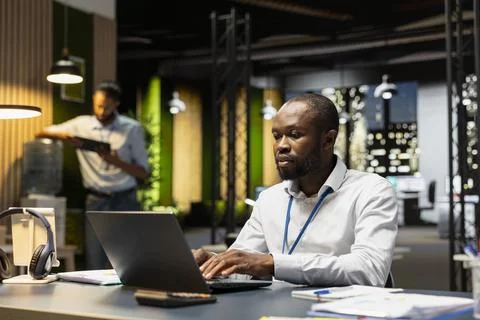 Employee completing spreadsheet on laptop, inputting and analyzing data Stock Photos