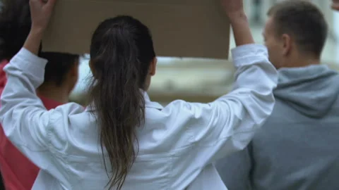 Employee crowd waving banners on strike, requiring better working conditions Stock Footage 115559088