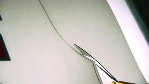 Employee cuts paper sewing pattern for hockey club uniform Stock Footage 143525721