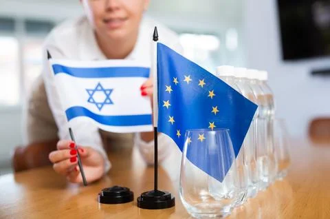 Employee of delegation prepares negotiating table - sets up flag of European Stock Photos