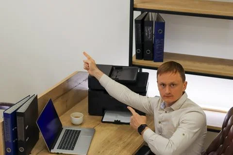 Employee emphasizing printer issue with pointing and approval sign Foto stock