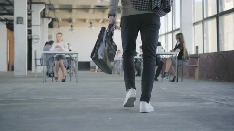 The employee enters the office. Throws a jacket at colleagues, takes popcorn Stock Footage 134154935