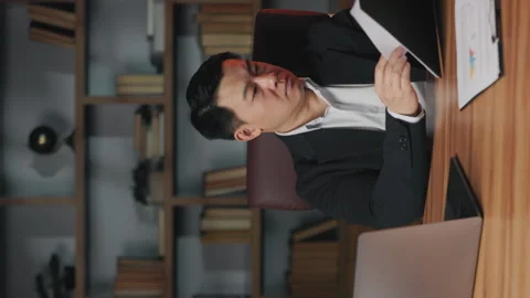 Employee examining data on clipboard in office with laptop Stock Footage 246737232