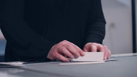 An employee in a factory assembles packaging from cut-out paper. Stock Footage 197462817