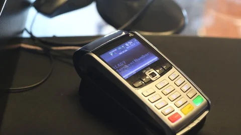 Employee getting end of day statement report on shop credit card machine Stock Footage 112173303