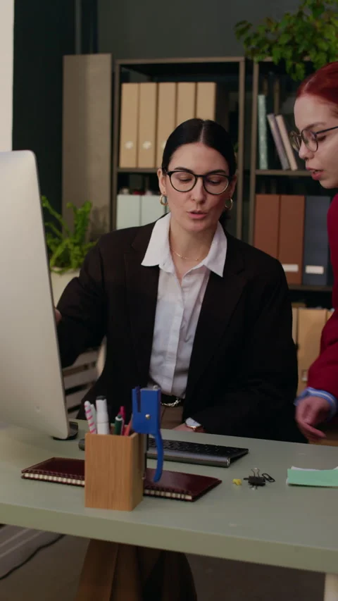 Employee Getting Help from Young Coworker Fixing Computer Issue in Office Stock Footage 327112604
