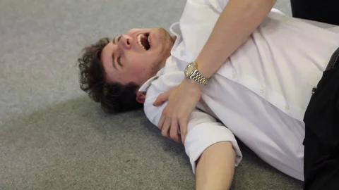 Employee has fallen over and lies on floor in pain Stock Footage 101373446