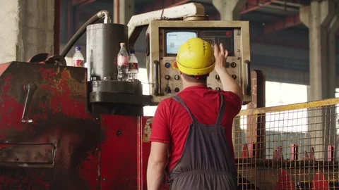 An employee in helmet operating a metal processing machine 스톡 동영상 120821865
