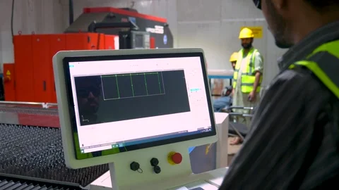 Employee Of A Machine Shop Programming A CNC Machine To Cut Steel During Stock Footage 328135516