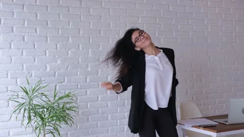 An employee of the office dances. He lets his hair down, throws a glass off his Stock Footage 192273724