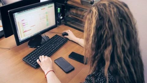 Employee in the office working with spreadsheets at the computer 스톡 동영상 197028926