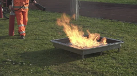 An employee performs a fire drill, putting out a fire with fire extinguisher. Stock-Footage 57625851