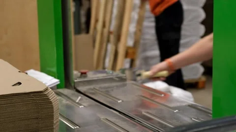 An employee puts boxes into a flat mold and packs them with a plastic harness. Stock Footage 257435289